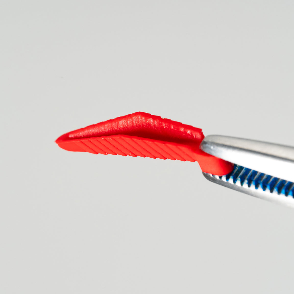 Red FlexiWedge interproximal wedge held in a placement instrument